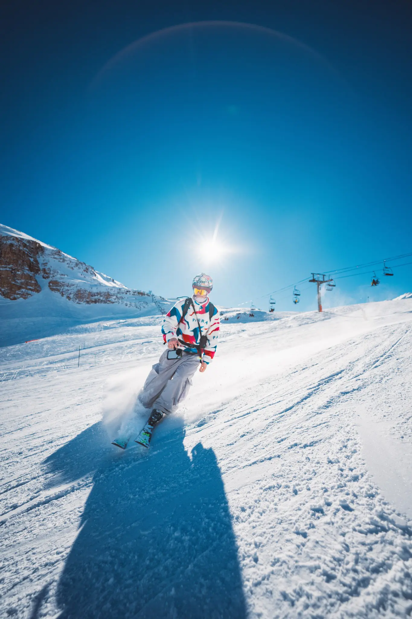skier carving down a snowy mountain slope on a sunny day