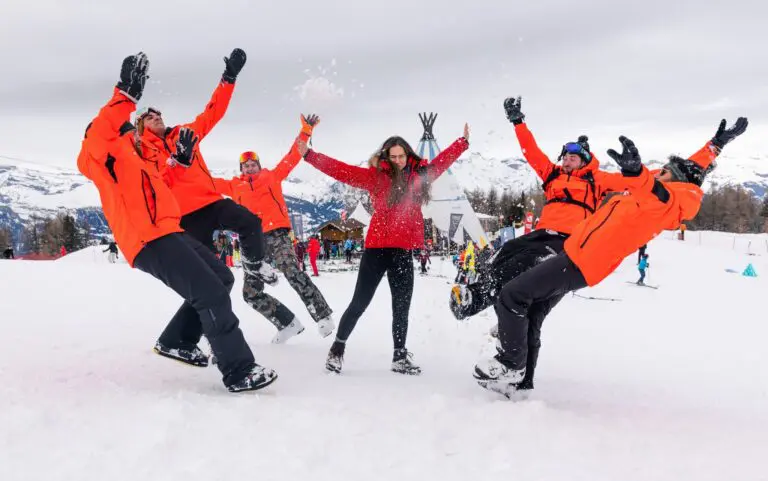 group of friends throwing snow in the air on a ski slope